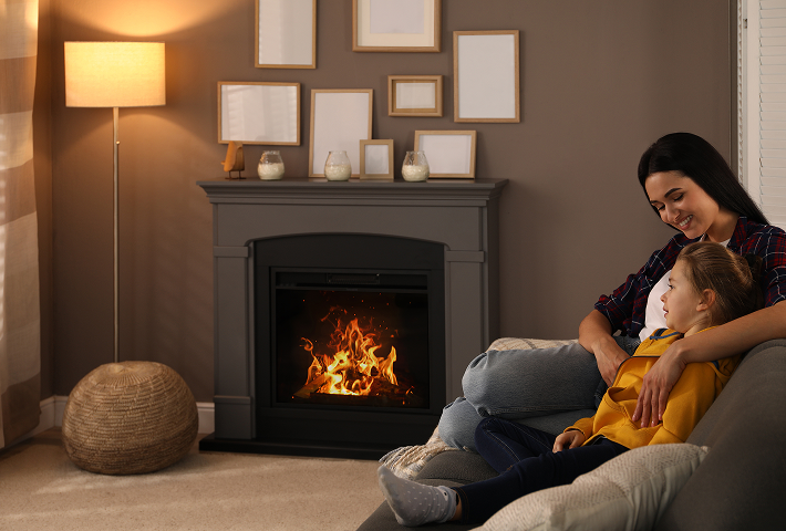 Cosy lounge setup with glowing electric fireplace, armchairs, and soft lighting