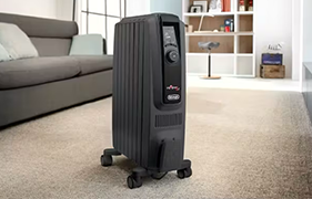 Black oil column heater placed in a cosy, carpeted living room
