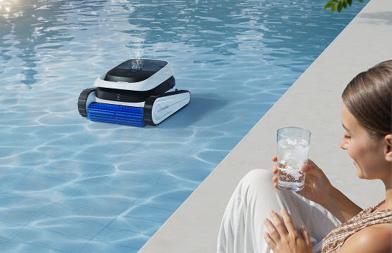 Aiper robotic pool cleaner cleaning an inground pool while a woman relaxes poolside