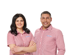Two Harvey Norman staff members wearing red striped uniforms smiling with arms crossed against white background 