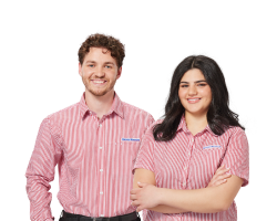 Two Harvey Norman staff members wearing red and white striped uniforms, smiling against a white background. 