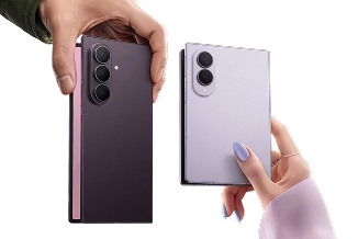Two hands hold an open Galaxy Z Fold8 Ultra and wider Galaxy Z Fold8, with their rear cameras and contrasting finishes visible.