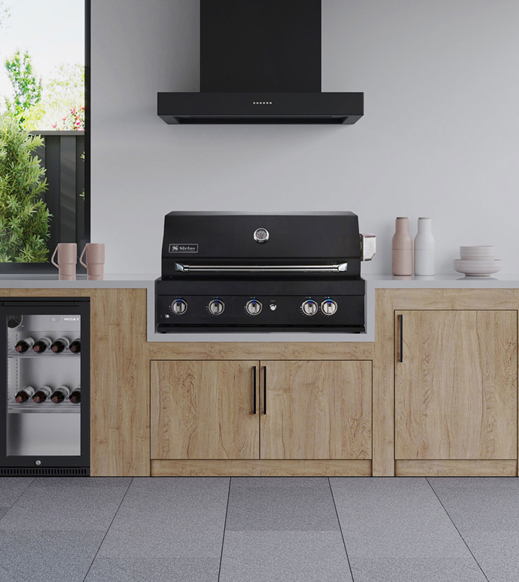 Built-in five-burner BBQ with rangehood and bar fridge in a modern outdoor kitchen 
