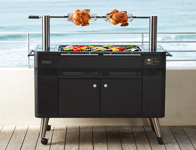 Everdure charcoal BBQ with rotisserie chickens and grilled vegetables overlooking the ocean 