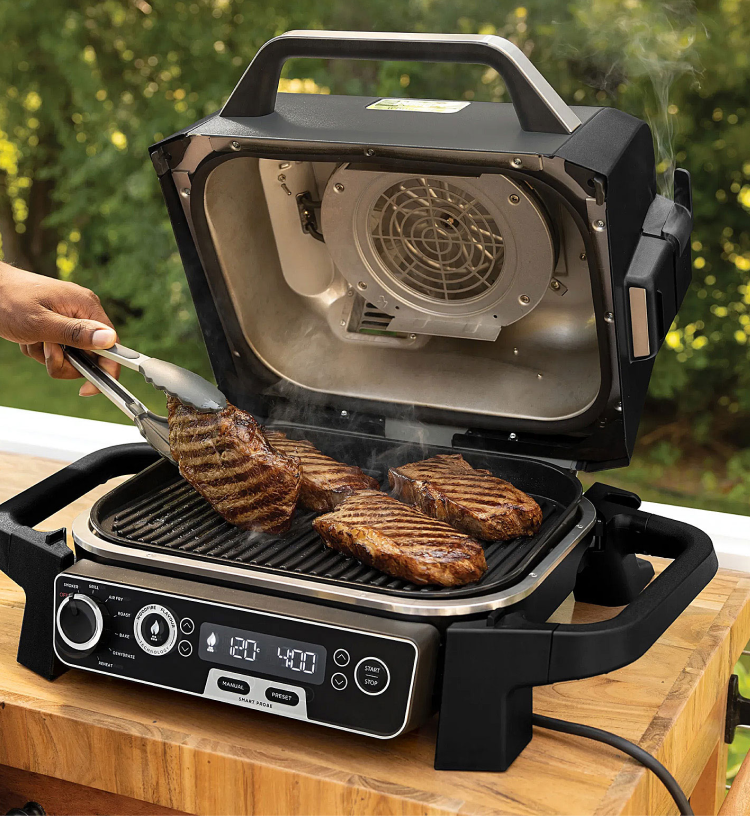 Steaks cooking on a benchtop electric BBQ with digital temperature controls 