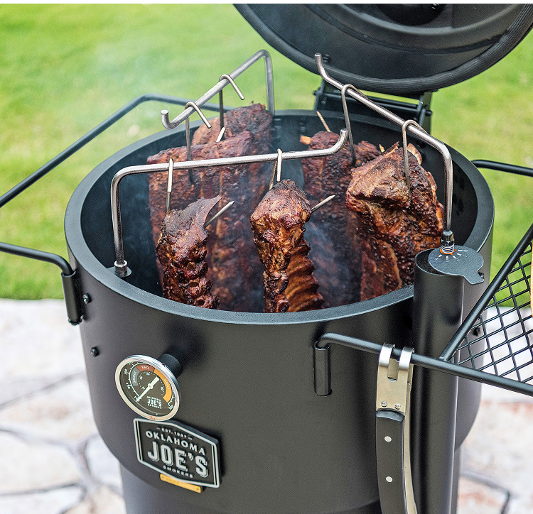 Oklahoma Joe’s drum smoker slow-cooking hanging cuts of meat outdoors 